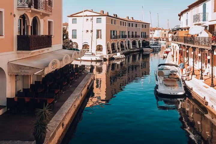 Scenic canal with moored boats and waterfront buildings in Port Grimaud, French Riviera