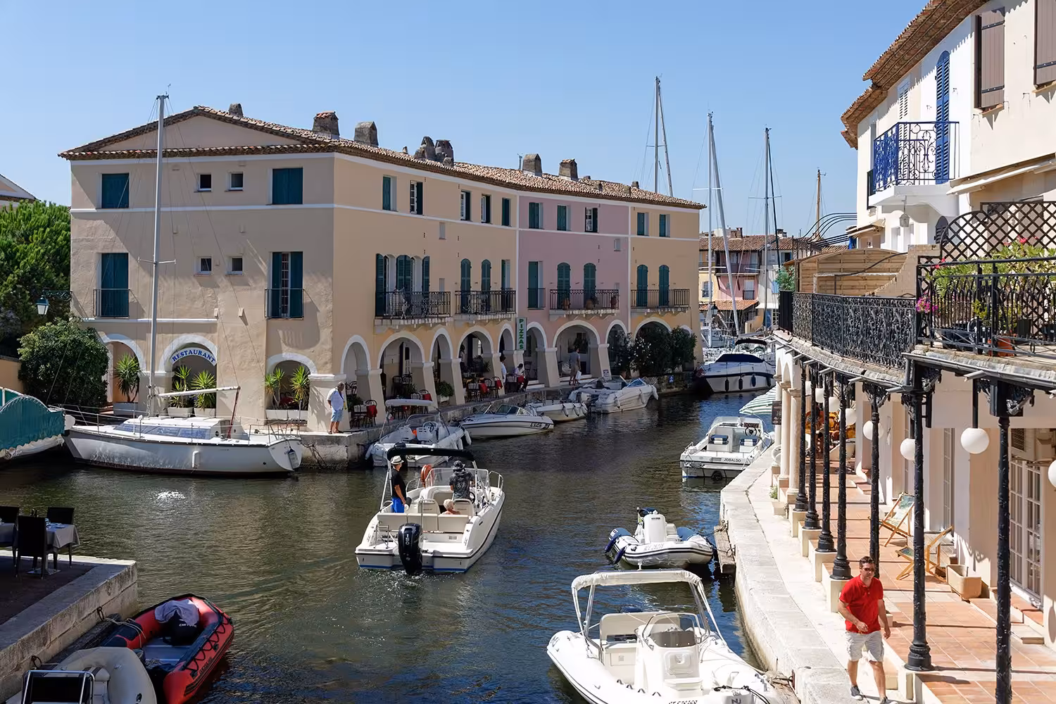 Colorful waterfront buildings and moored boats along a canal in Port Grimaud, French Riviera