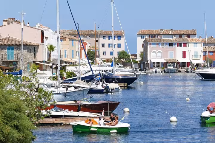 Colorful boats and sailboats moored in Port Grimaud canal with pastel waterfront buildings