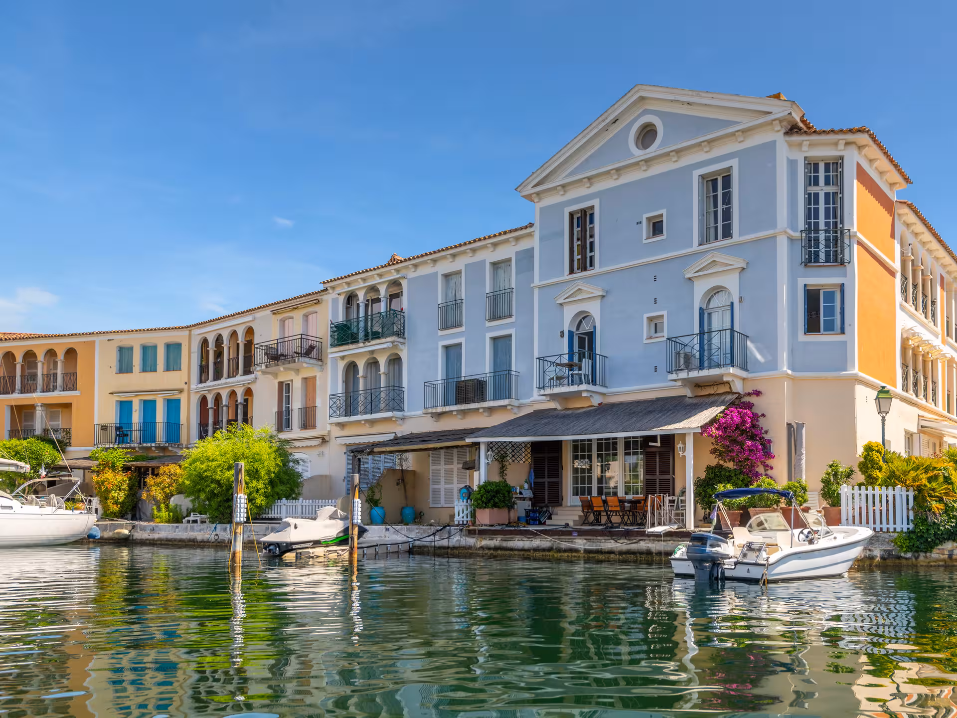 Colorful waterfront buildings with boats moored along the canals of Port Grimaud, French Riviera