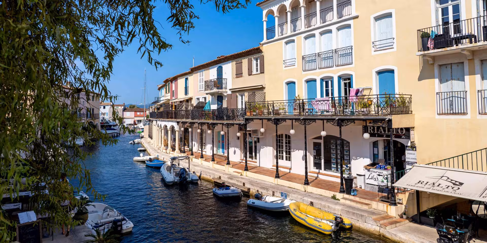 Colorful waterfront buildings and small boats along the canal in Port Grimaud, French Riviera