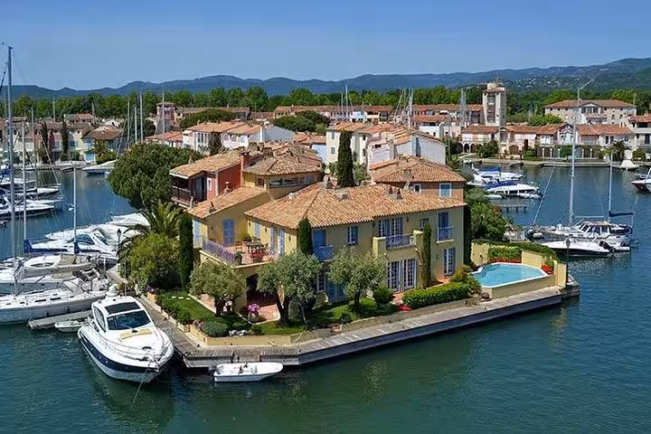 Aerial view of colorful waterfront villa with pool and boats in Port Grimaud marina, French Riviera