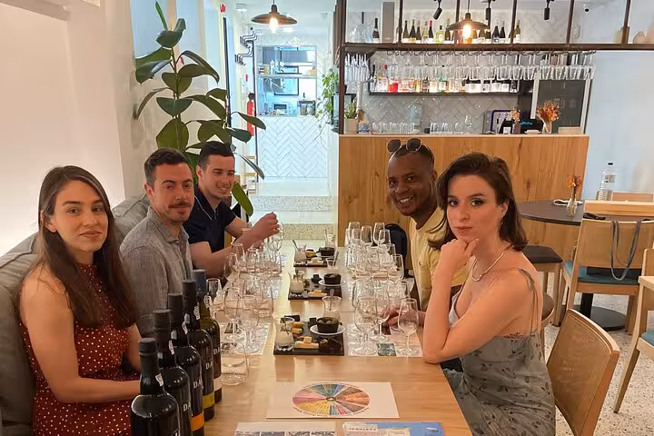 Guests enjoy a sommelier-led tasting of five Port wines with curated pairings in a cozy wine bar for small-group bookings.