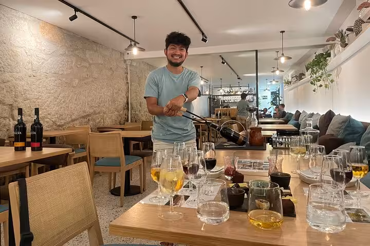 Sommelier demonstrates Port service in a boutique tasting room, with five-wine flights, decanters and bites on the table.