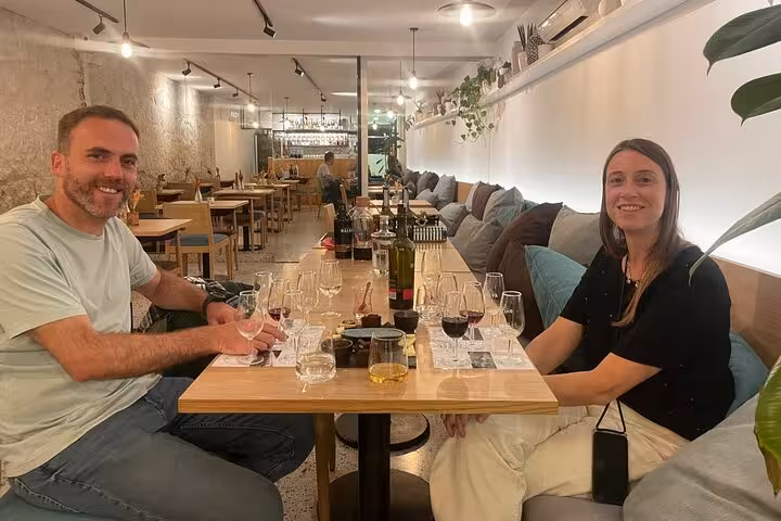 Guests enjoying a sommelier-led tasting flight of five Port wines in a modern Porto wine bar with curated pairings.