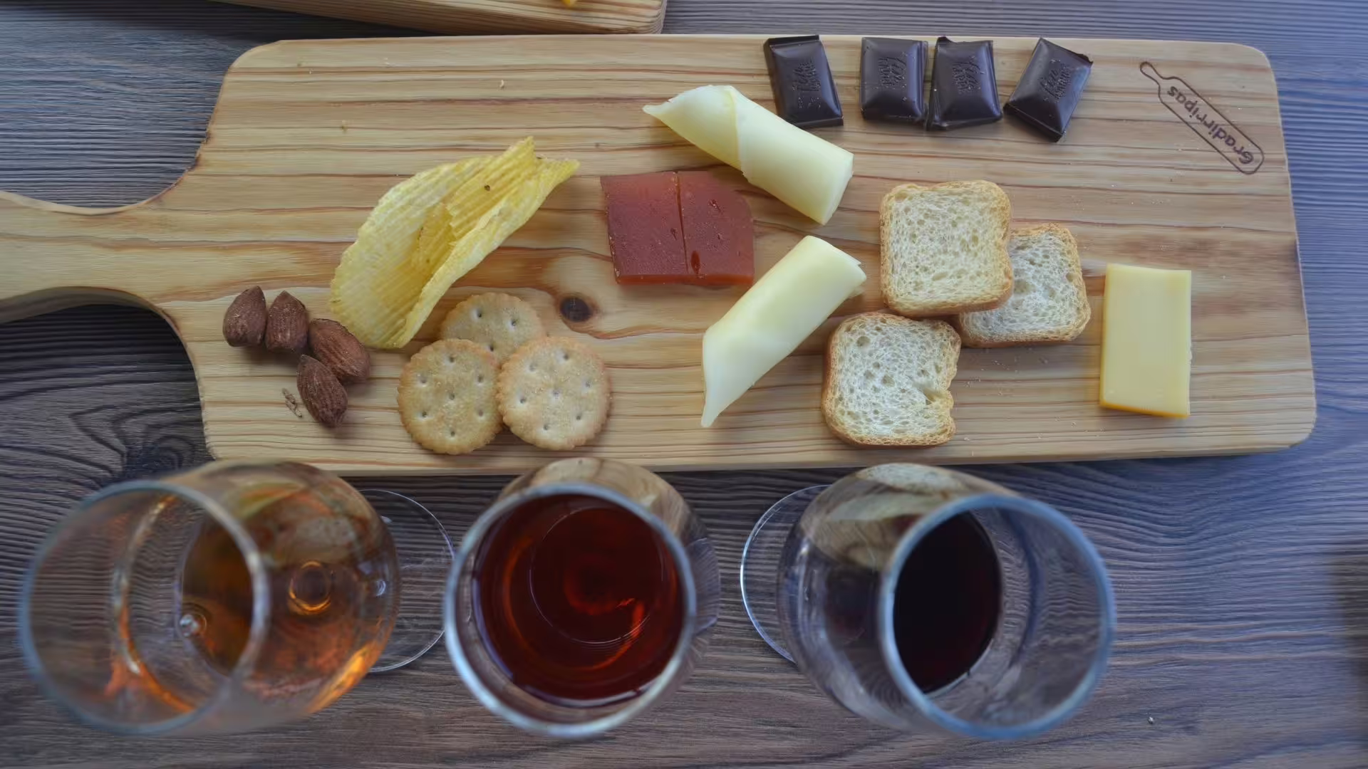 Image of three different type of Port Wines served with cookies, cheese, chips, almonds and chocolat
