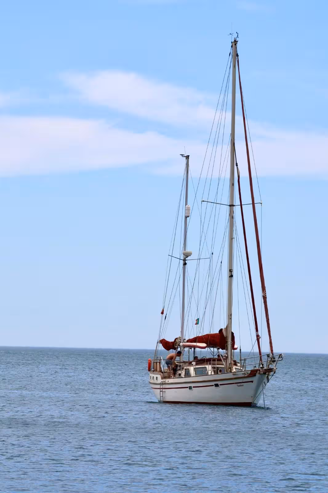 Classic white sailboat anchored on calm blue waters during a scenic Portimao romantic sunset sailing tour