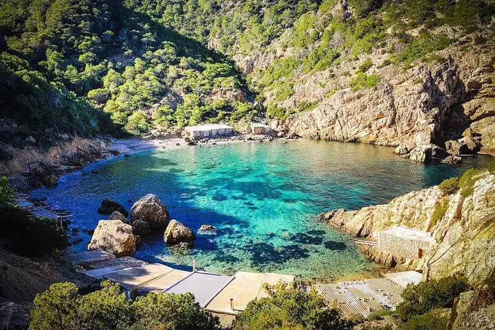 Turquoise Portitxol cove in Javea with rocky cliffs and pine forest, scenic stop on jet ski excursion