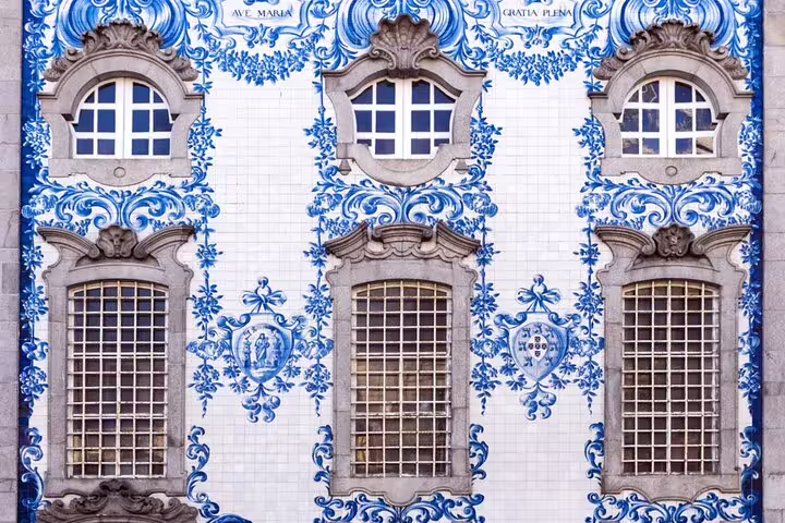 Blue and white azulejo tile facade with ornate baroque windows in Porto, Portugal