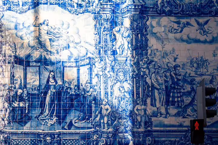 Intricate blue azulejo tiles depicting historic scenes adorn a wall in Porto, a highlight of the guided Tuk Tuk tour.