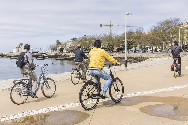 Small group cycling along Porto's scenic waterfront during a vibrant 3-hour bike tour experience.