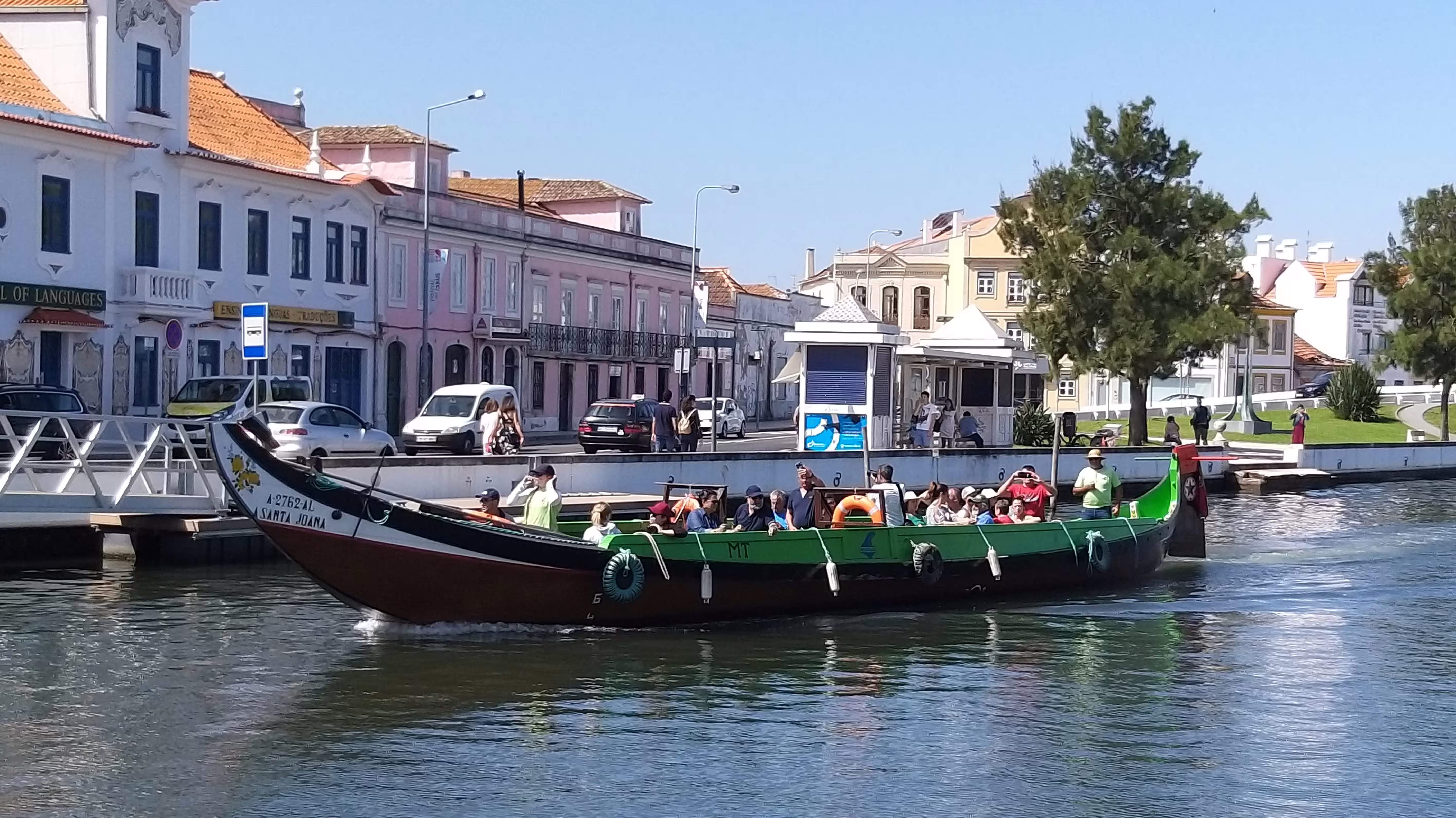 A traditional boat glides through Aveiro's canal, offering scenic views and cultural richness on your Porto to Castelo Branco transfer.