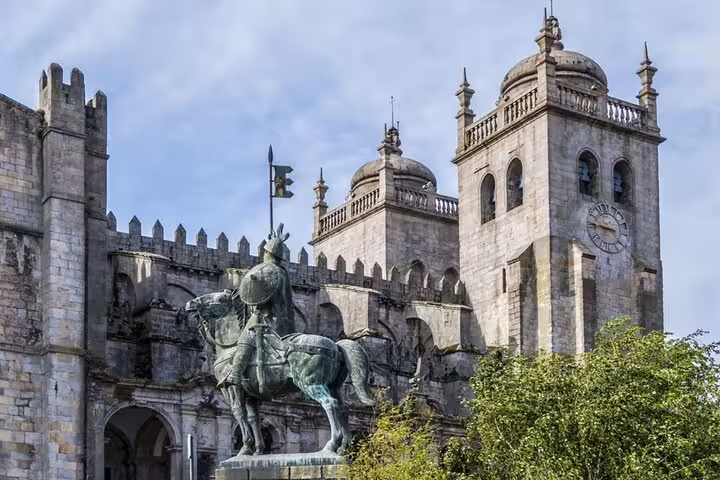 Equestrian statue in front of Porto Cathedral with clock tower and battlements