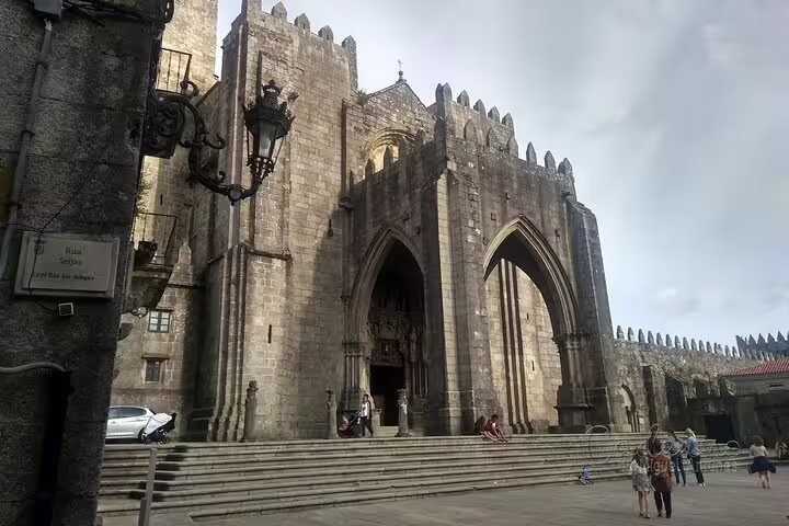 The majestic Porto Cathedral stands tall with its gothic architecture, attracting visitors on a sunny day.