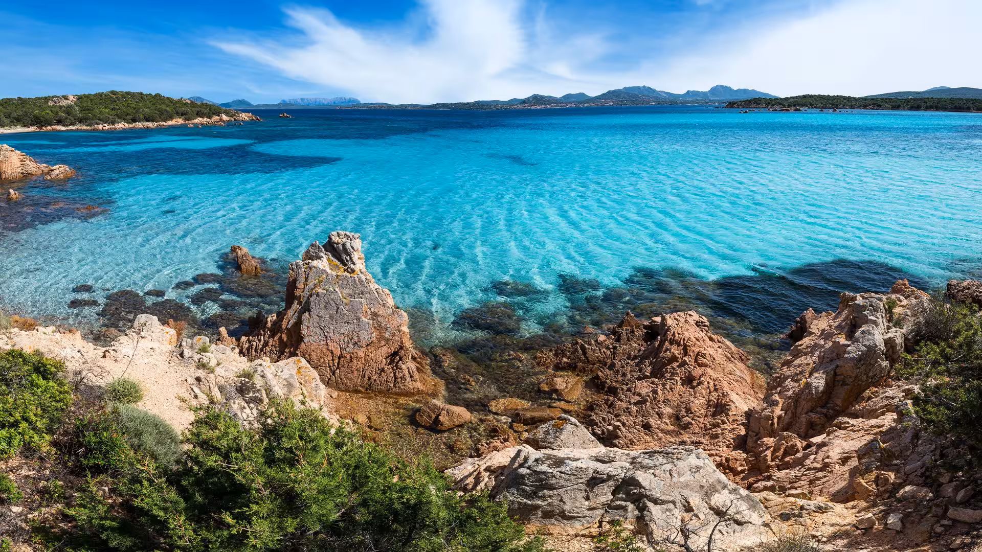 Panoramic view of the clear blue sea and rocky coastline near Porto Cervo, perfect for scenic boat tours in Sardinia.