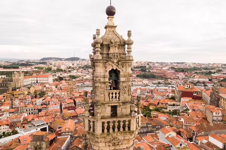 Aerial view of Porto highlighting the iconic Clerigos Tower against a backdrop of red-tiled rooftops.