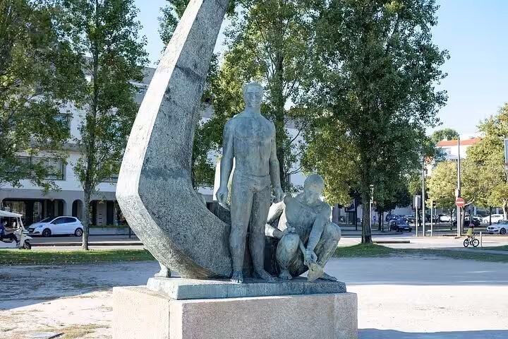 Bronze sculpture of two figures in Porto public square during coastal walking tour