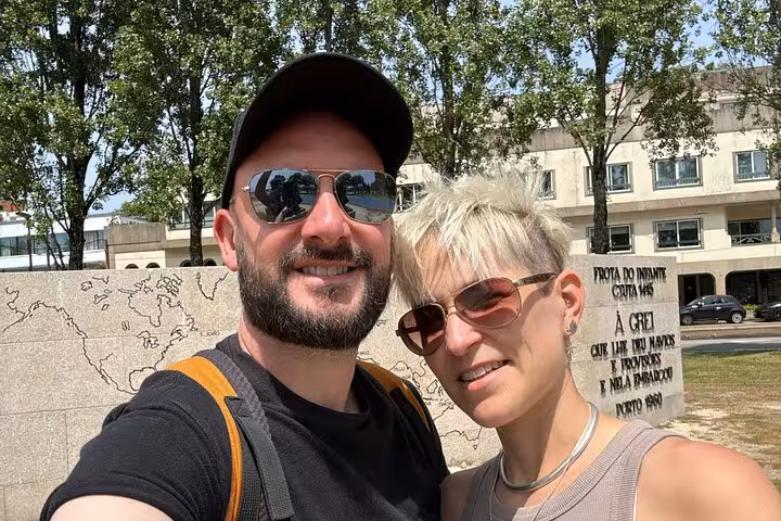 Couple taking selfie in front of Porto monument during outdoor walking tour