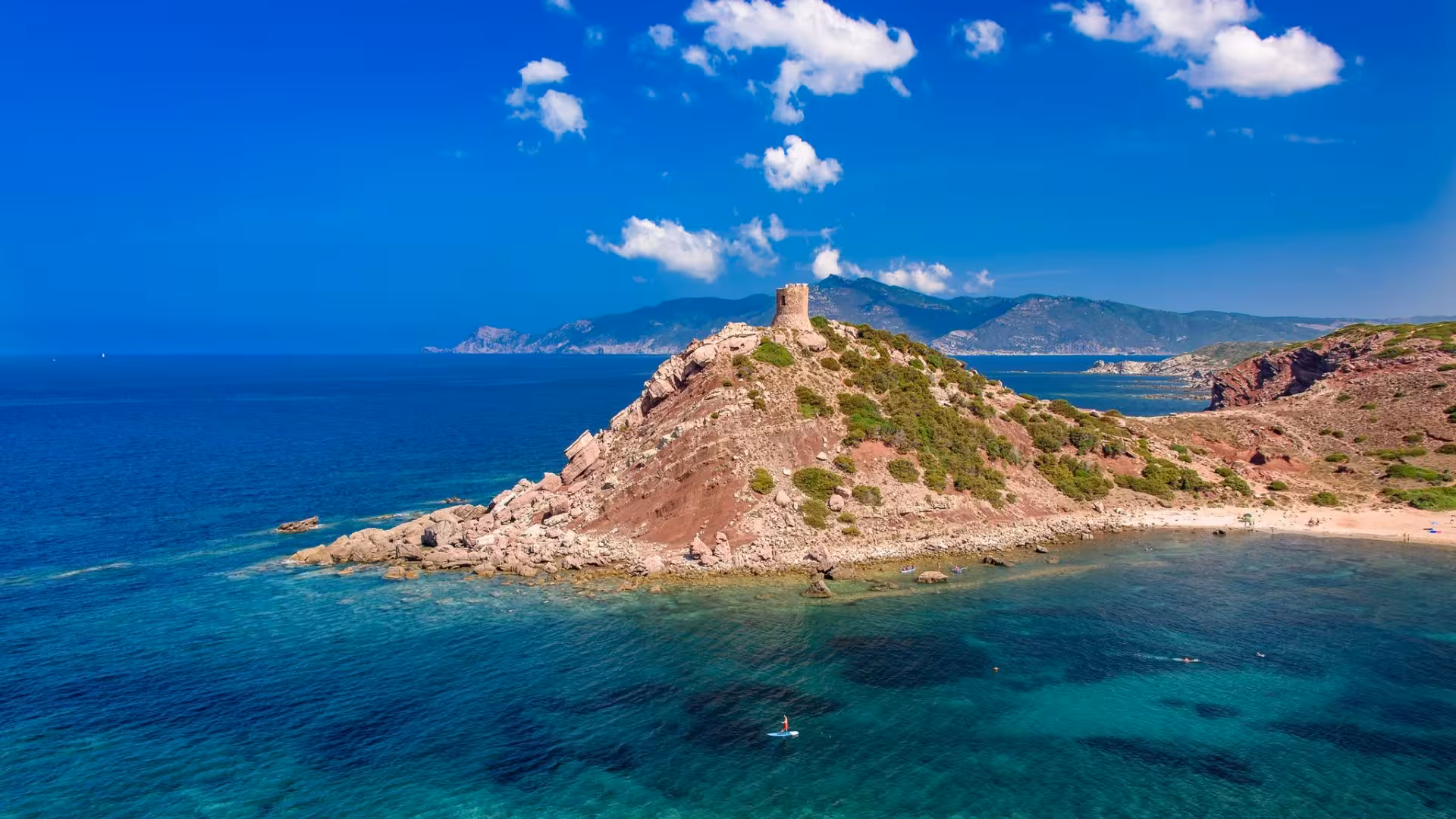 Stunning aerial view of the rugged coastline and clear waters of Porto Conte Park, perfect for a minivan tour.