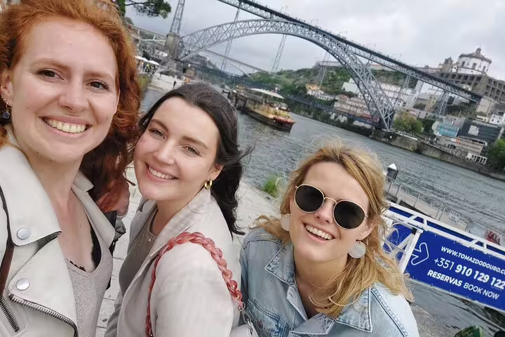 Friends selfie by Dom Luís I Bridge on a Porto scavenger hunt and sights self-guided tour by the Douro
