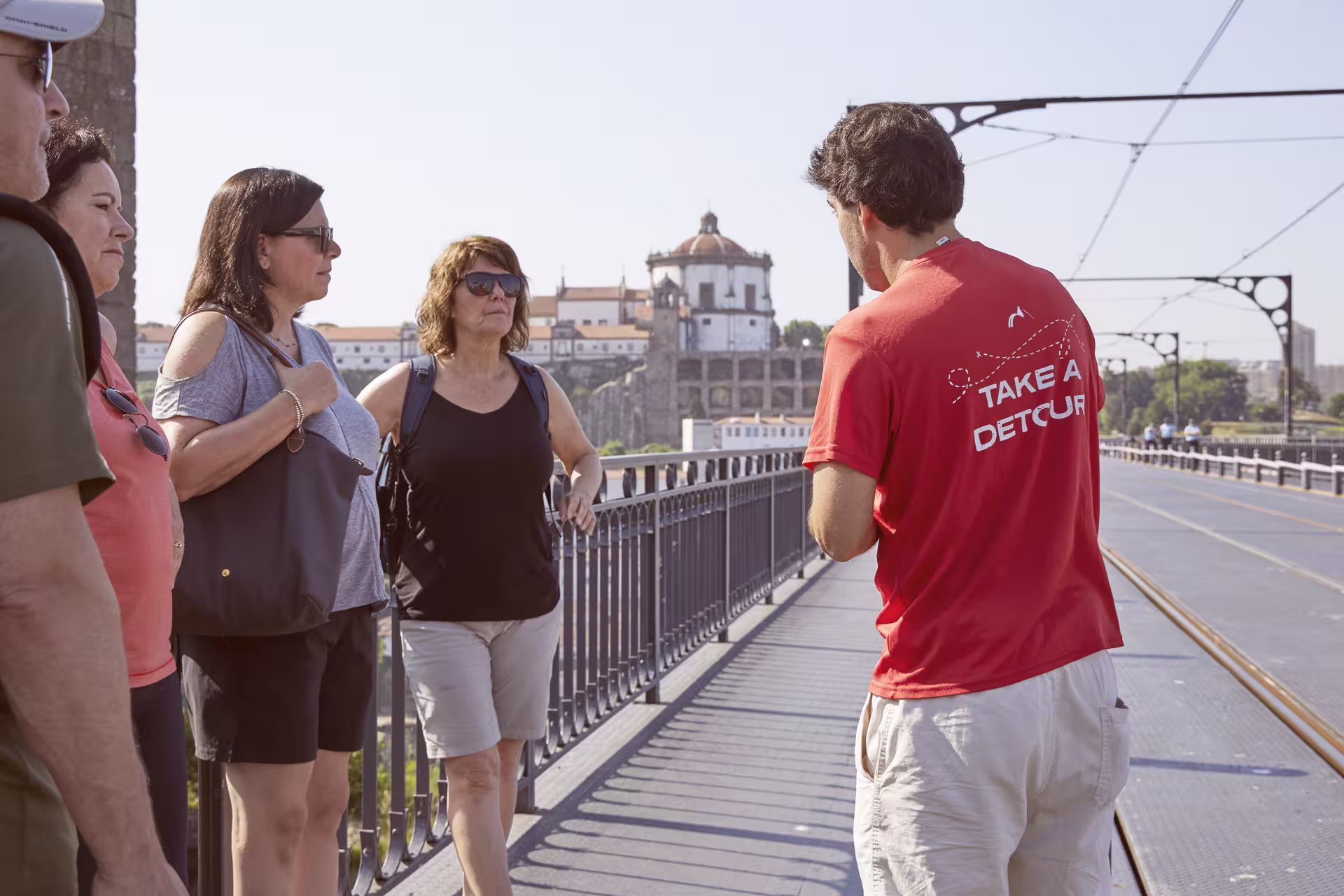 Tour guide leads a group on Porto's Dom Luís I Bridge, capturing the city's historic architecture and scenic views.