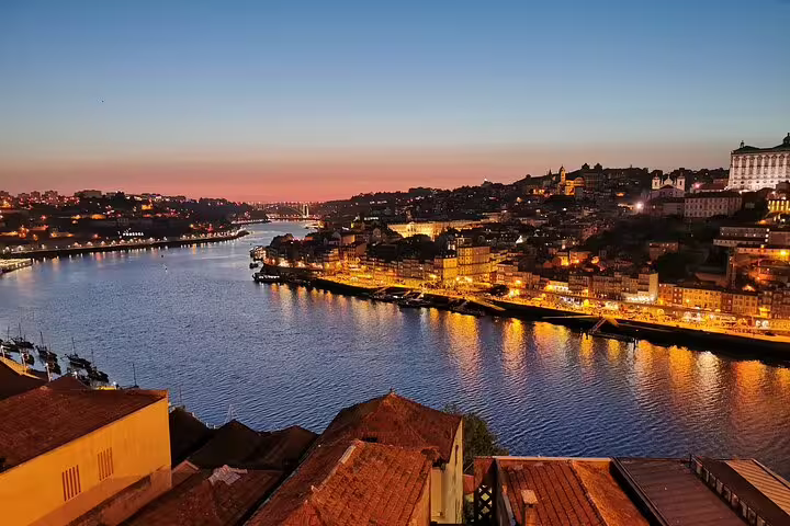 Scenic sunset view of Porto's historic waterfront along the Douro River, perfect for a private day trip from Lisbon.