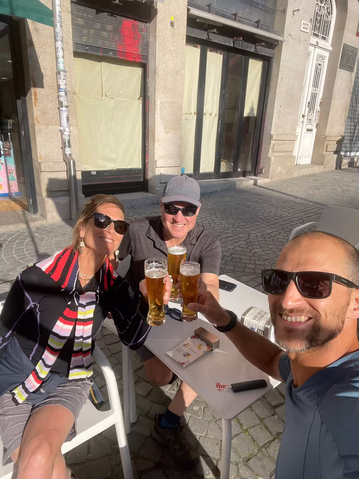 Tourists toast with local drinks at a sunlit café in Porto, capturing the relaxed vibe of the E-bike and seafood experience.