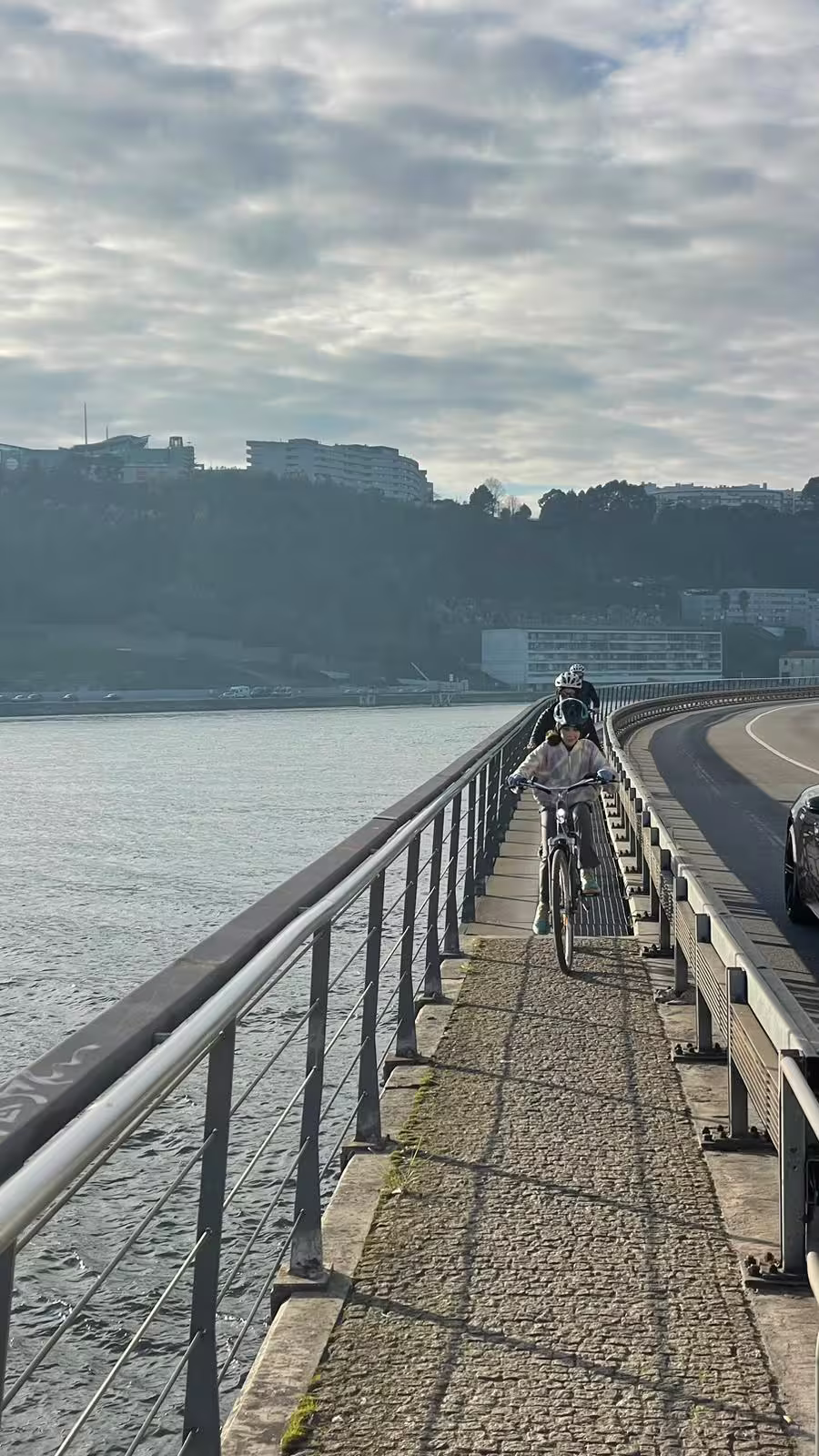 Cyclists enjoy a scenic ride along Porto's Douro River on an e-bike tour, highlighting urban landscapes and waterfront views.