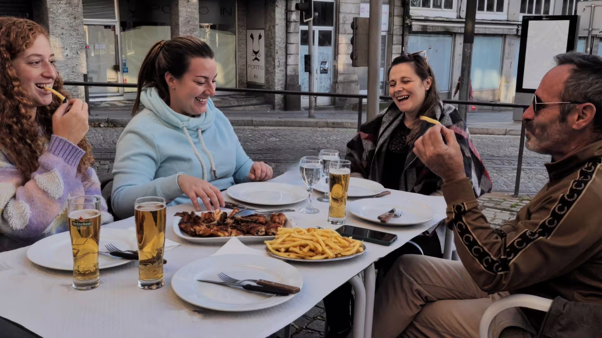 Small group guests enjoying a Portuguese Barbecue on a restaurant terrace during Cooltour Oporto's Porto Food Tour