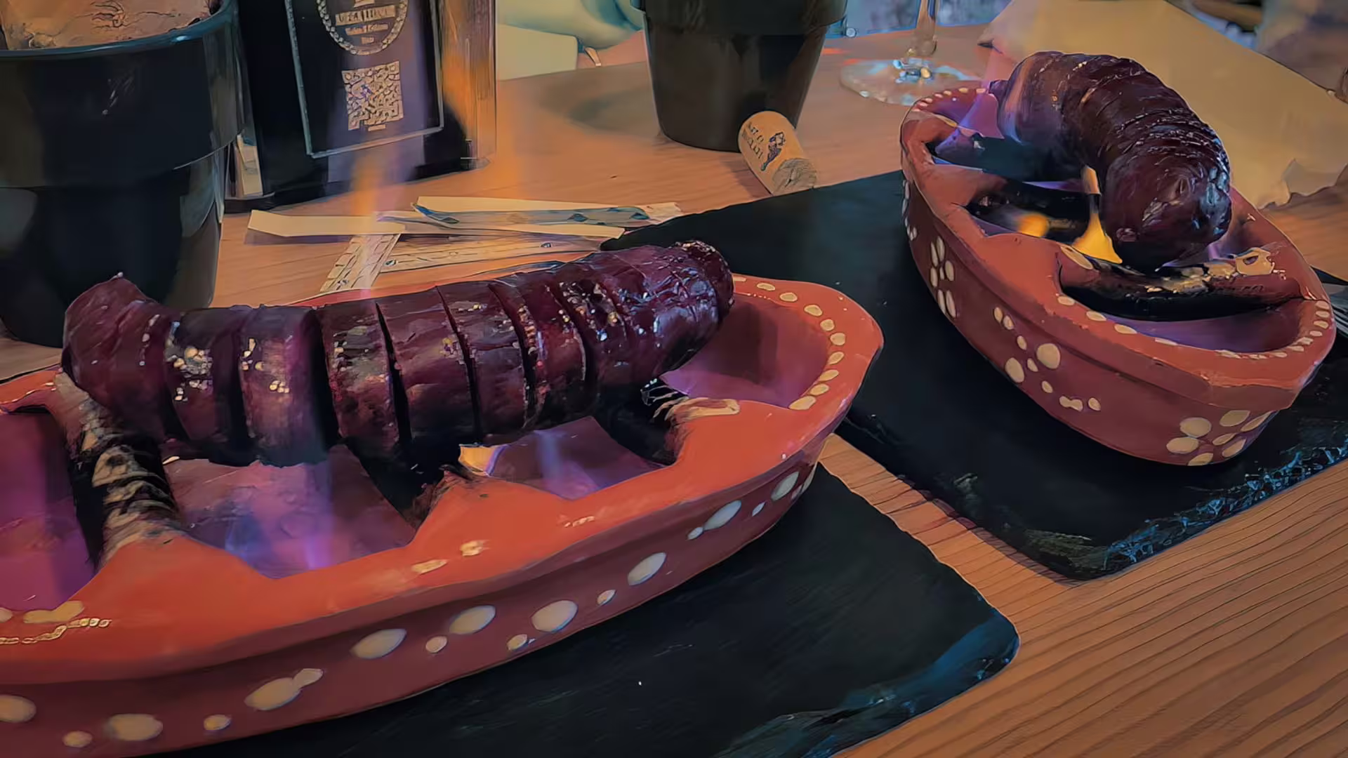 Roasted chorizo on clay board over fire, part of Cooltour Oporto's Porto Food Tour