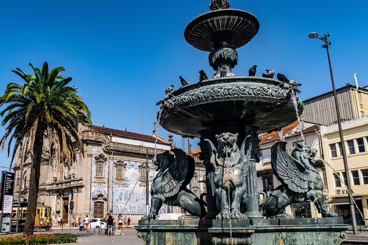 Elegant fountain with mythical creatures in a vibrant Porto square, perfect for a full-day private tuk tuk city tour.