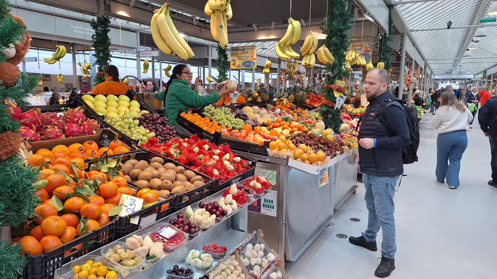 Vibrant fruit market in Porto bustling with tourists and locals, perfect stop on a private afternoon tour of the city.