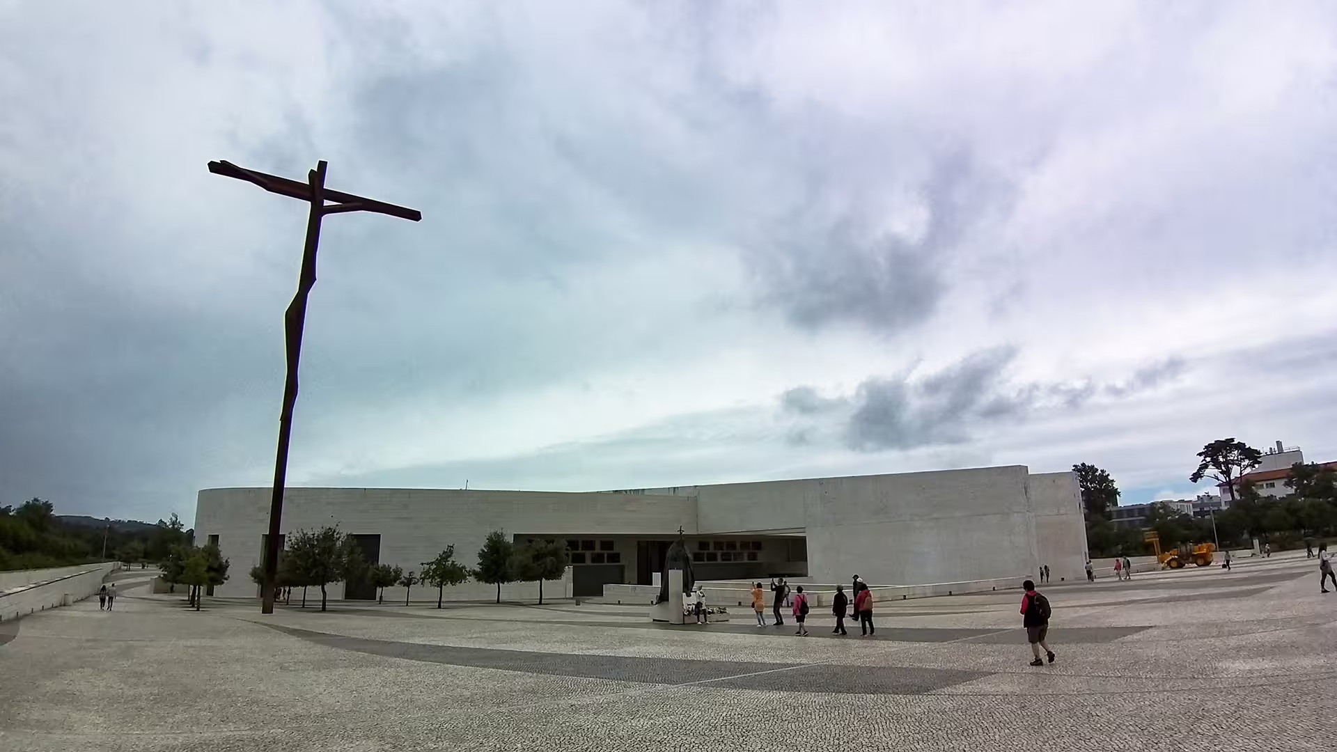 Visitors explore the Sanctuary of Fátima, a key stop on the customizable Porto to Lisbon private tour, beneath a cloudy sky.