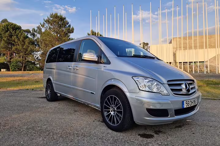 Comfortable silver minivan parked in a scenic area, ideal for Porto to Lisbon private transfers.