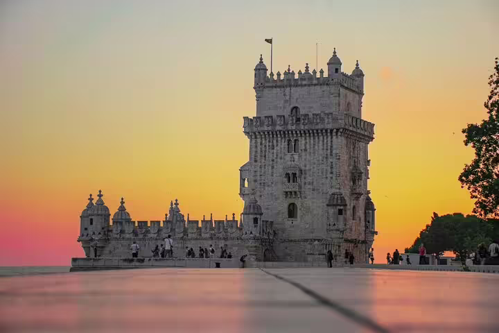 Sunset over the historic Belém Tower in Lisbon, a must-see landmark on the Porto to Lisbon private transfer route.