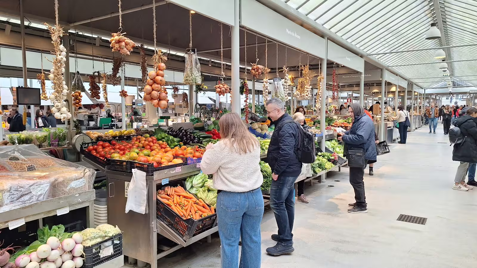 Visitors explore a vibrant local market in Porto, showcasing fresh produce and authentic Portuguese culture on a private afternoon tour.