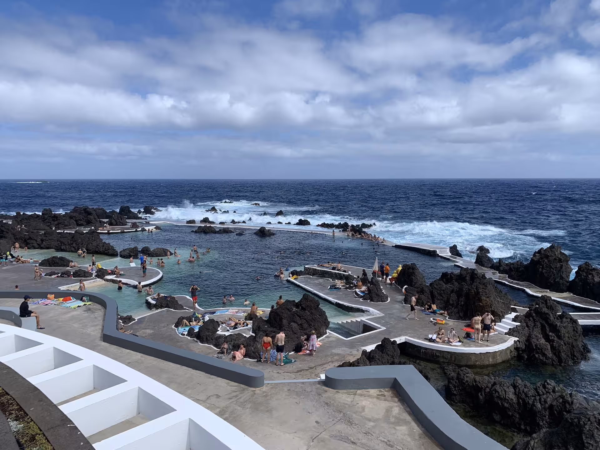 Visitors enjoying natural lava rock pools at Porto Moniz on a private guided small group tour in Madeira