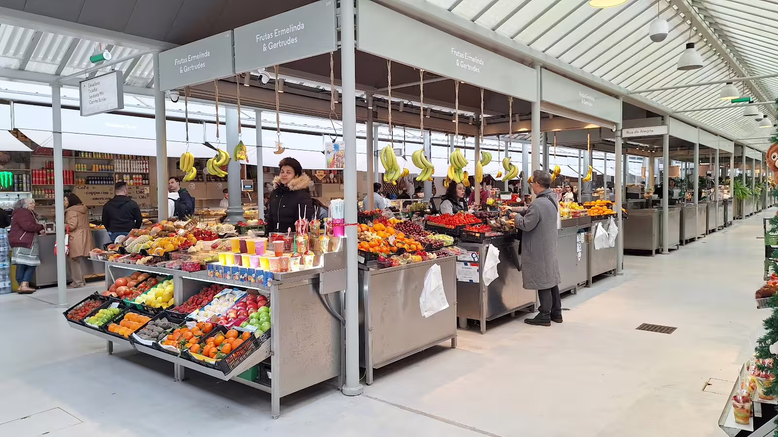 Vibrant Porto market scene with fresh fruits and visitors, showcasing local culture on a guided private morning tour.