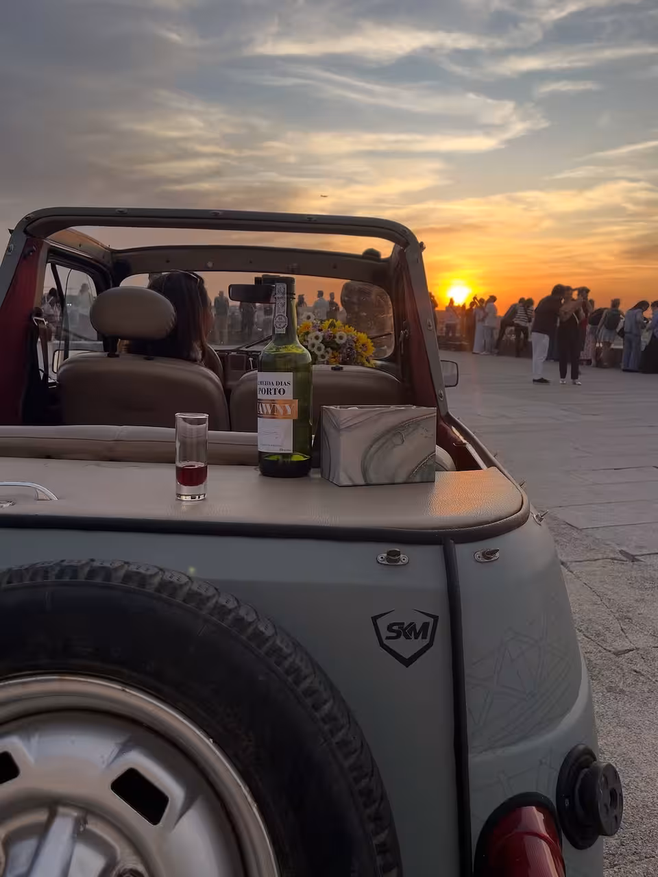 Port wine toast at sunset in a classic car on Porto by Night tour, golden skies over the Douro River