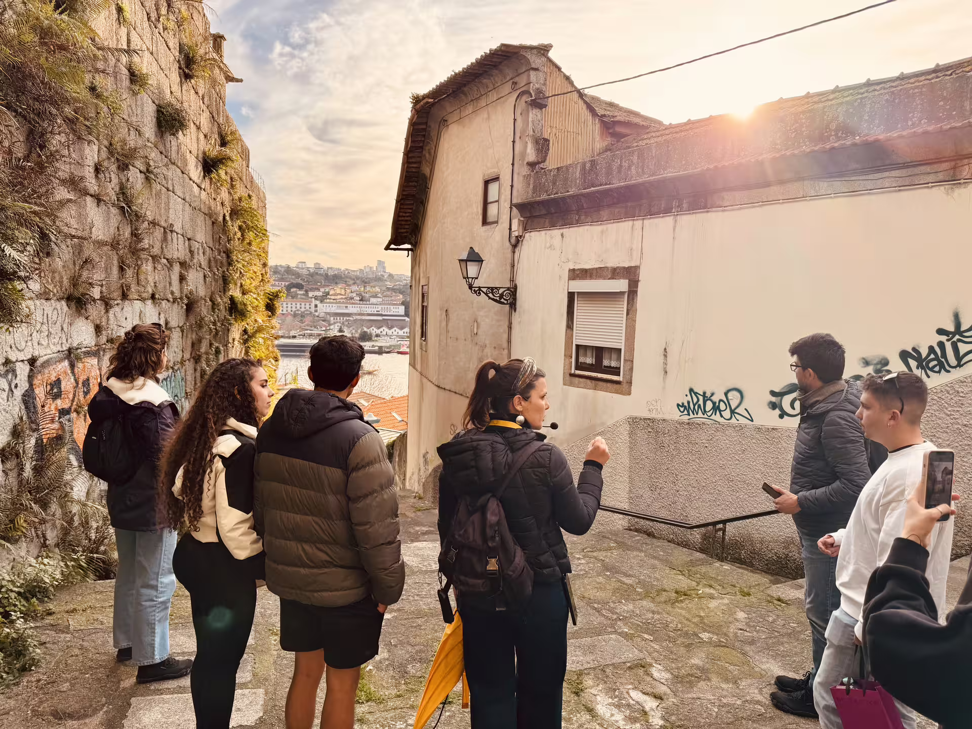 Tour group explores Porto's historic old town with views of the Douro River, ideal for small-group walking tours and river cruises.