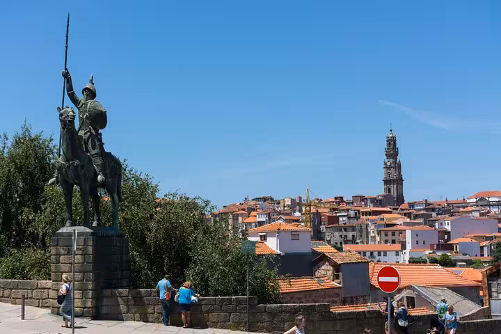 Equestrian statue overlooking Porto old town rooftops with Clerigos Tower in background