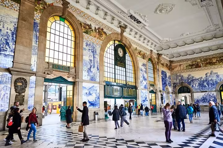 Historic São Bento train station in Porto with blue azulejo tile murals and arched stained glass windows