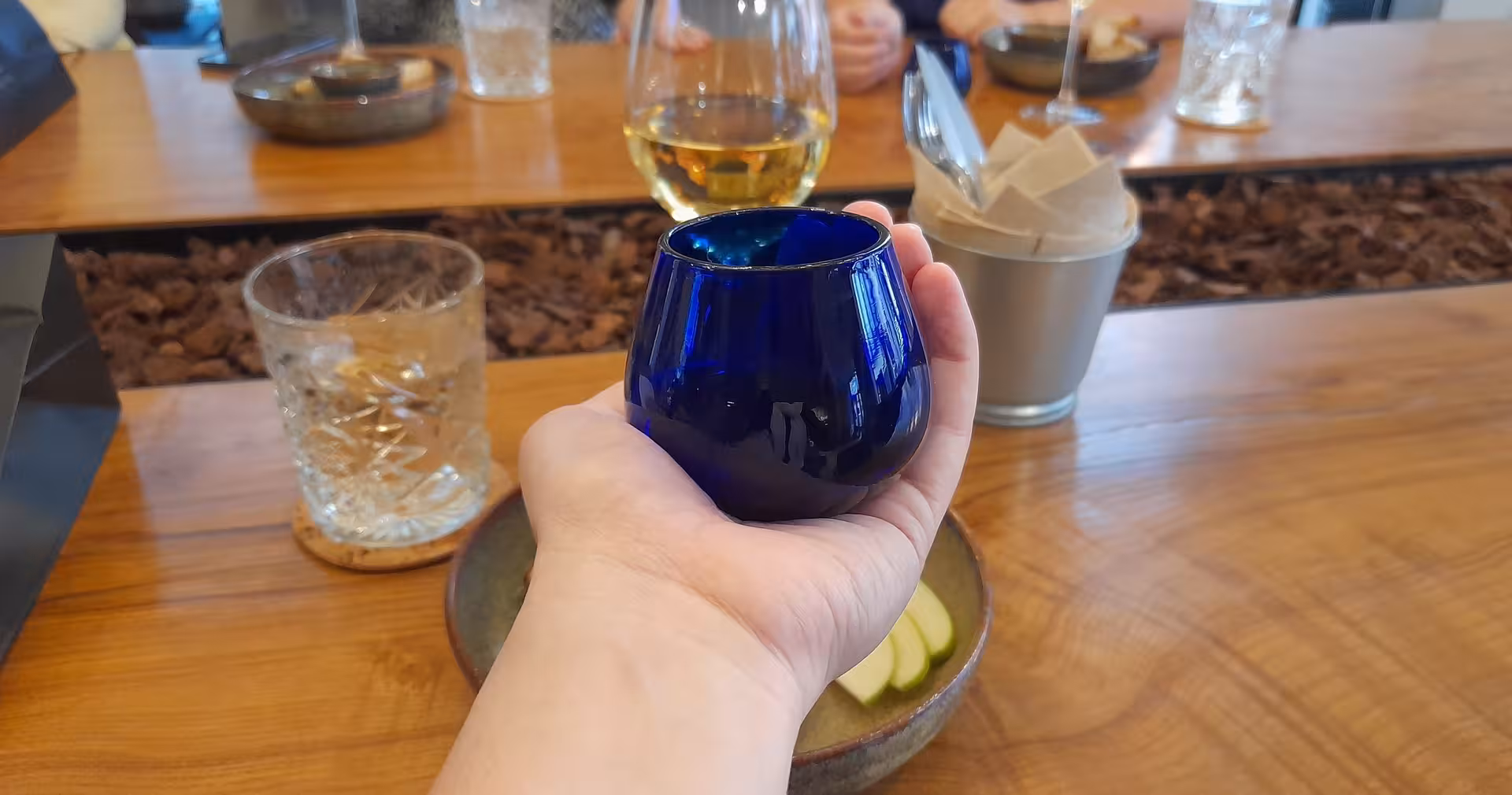 Blue tasting cup held over table during Porto olive oil tasting tour with local guide and food pairings