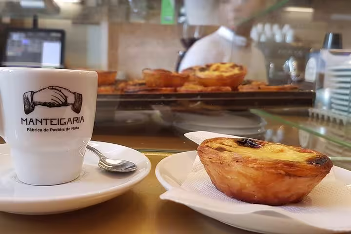 Traditional pastel de nata and coffee at Manteigaria, offering a taste of Porto's famous pastry on food tour.