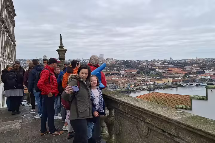 Tourists enjoy panoramic views of Porto's historic architecture and Douro River during a private afternoon tour.