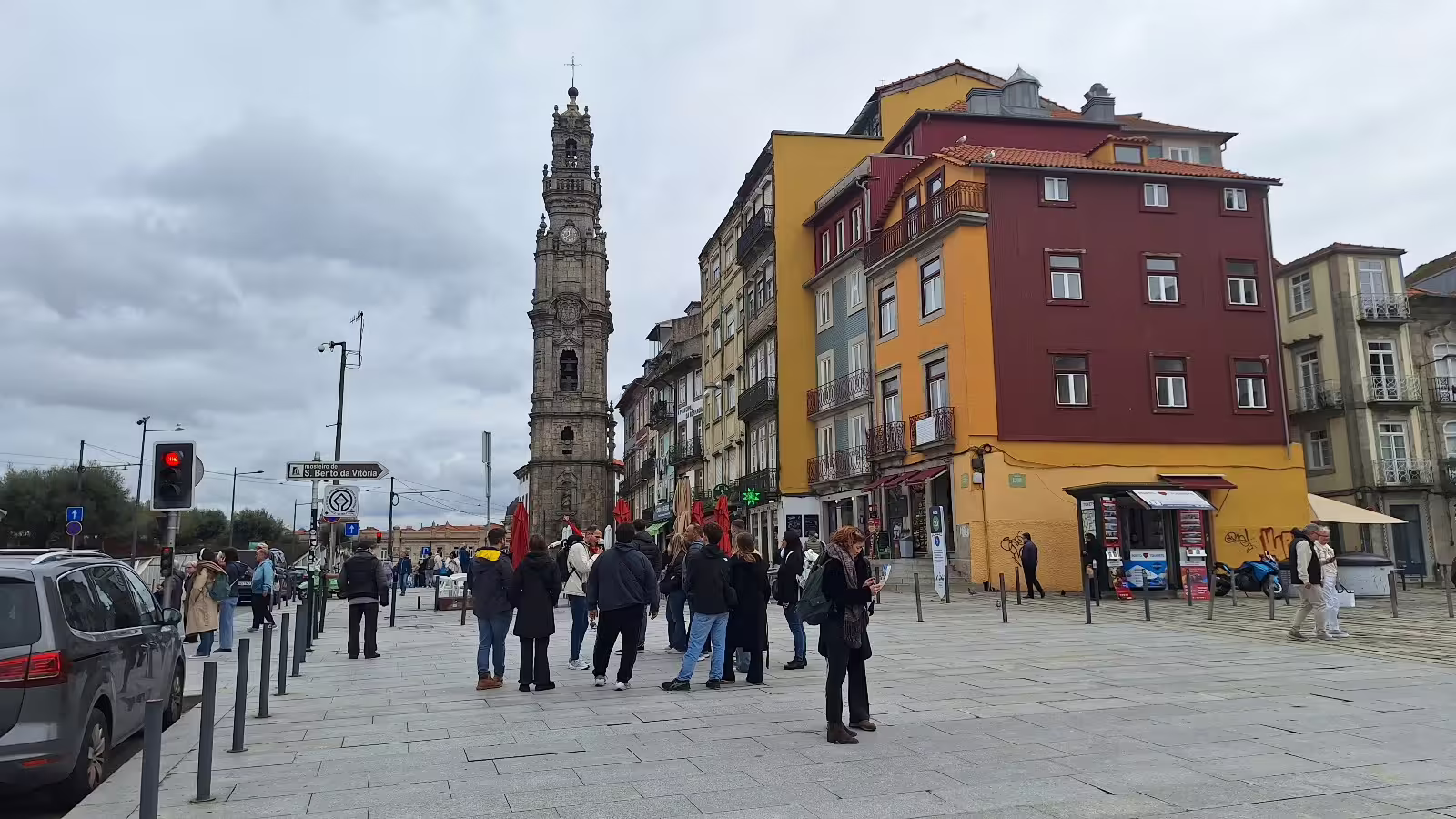 People exploring Porto's historic center with the iconic Clerigos Tower in the background during a private morning tour.