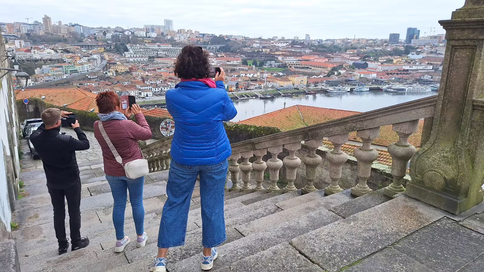 Visitors capturing scenic views of Porto's historic architecture and Douro River on a private morning tour.