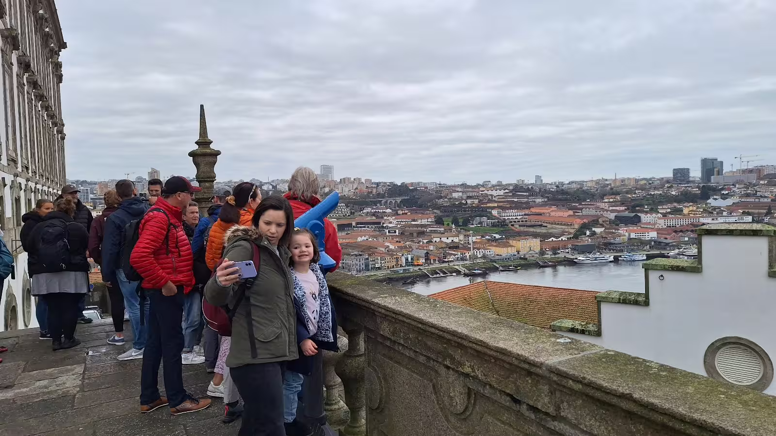 Tourists enjoying a scenic view of Porto's historic cityscape and Douro River on a guided private morning tour.