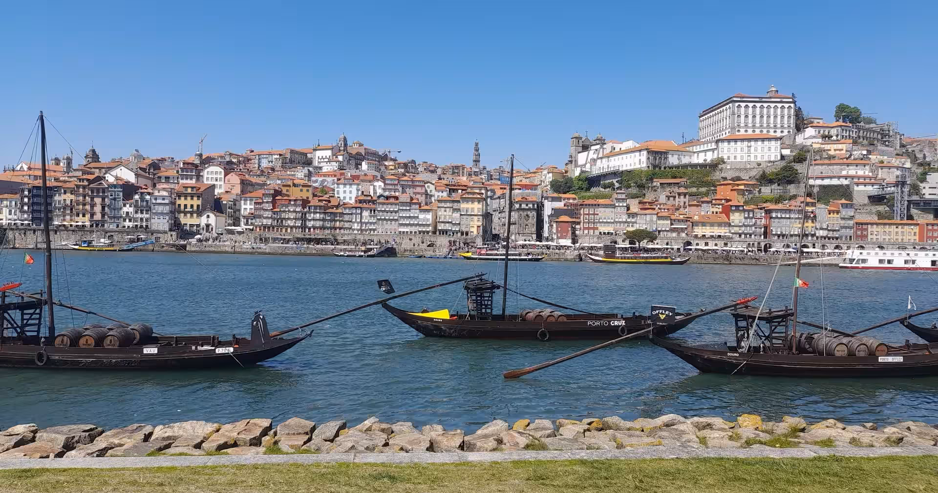 Rabelo boats on the Douro with Ribeira waterfront views, a key stop on Porto half-day small-group walking tour