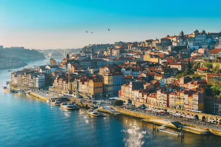 Scenic view of Porto's colorful Ribeira district along the Douro River, highlighting vibrant architecture and tranquil waters.